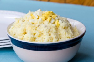 Mashed Potato salad in a white bowl with blue rim.