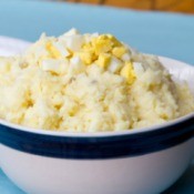 Mashed Potato salad in a white bowl with blue rim.