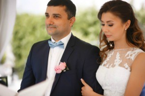 Bride and Groom.  Groom is wearing a blue bow tie and pink boutonniere