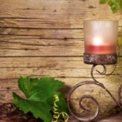 Candle on wrought iron scroll design holder with imitation grape vines