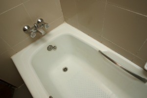 Standard white bathtub with tile surround