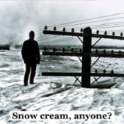 black and white photo of man standing on snow bank up to the lower cross member of a power pole