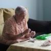 Elderly woman stringing beads