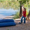 Woman pumping up air mattress in the woods