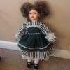 doll wearing a striped dress with green overskirt