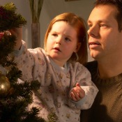 Father and young girl decorating a Christmas tree