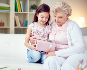 Grandmother and Granddaughter holding pink wrapped present