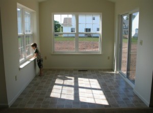 Child Looking out Window in a room with vinyl flooring