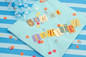 "You're Invited" Spelled out on a napkin