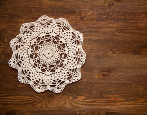 crochet lace doily on dark wood background