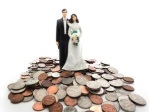 Bride and groom figures standing on a smile of coins