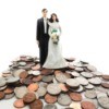 Bride and groom figures standing on a smile of coins