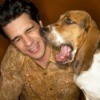Yawning beagle next to man making a yucky face