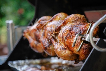 Rotisserie style chicken being made on a home BBQ