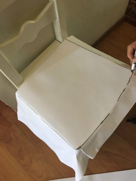 Marking the seat of the chair on paper.