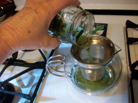 Pour steeped leaves into a tea strainer.