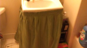 A sink skirt attached with tape.