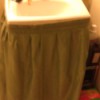A sink skirt attached with tape.