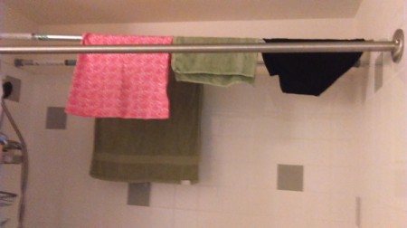 laundry drying on curtain tension rods