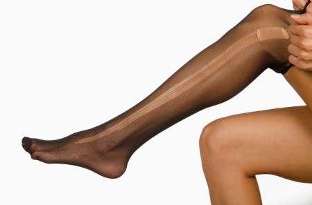 Women's leg with black hose that have a run in them