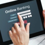 Hands using a tablet displaying the words "Online Banking"