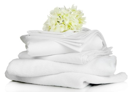 Stack of white linens with a white flower resting on top