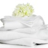 Stack of white linens with a white flower resting on top