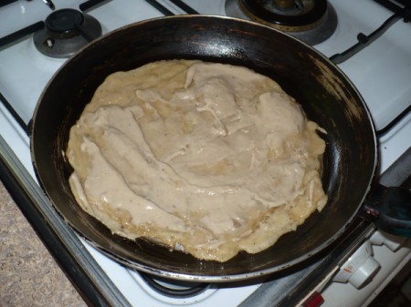 Banana mixture on top of crepe in pan.