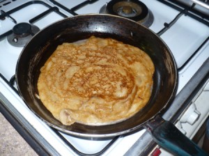 A banana crepe being cooked in a skillet.