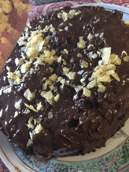 A chocolate cake with potato chips on the chocolate dressing.