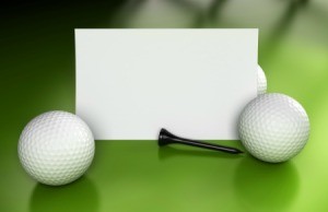 Blank card golf balls and golf tees displayed against a green background