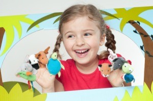 Little girl with finger puppets in puppet theater