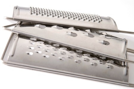 Stack of three cheese metal cheese graters with different hole sizes