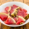 Several slices of pickled watermelon in a white bowl