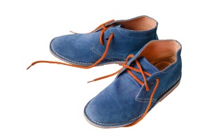 Pair of blue suede shoes on white background