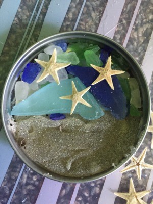 display of beach sand, sea glass, and tiny sea stars