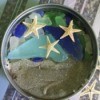 display of beach sand, sea glass, and tiny sea stars