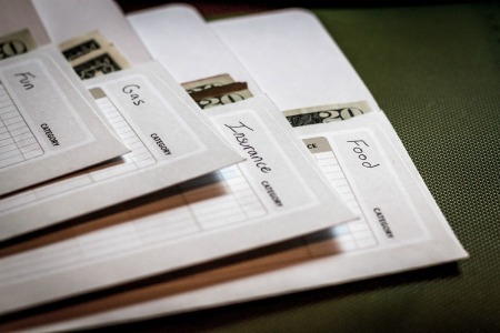 Envelopes containing cash labelled Fun Gas, Insurance, and Food.