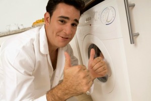 Man giving two thumbs up in front of clothes dryer