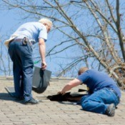Two men working on a home's roof