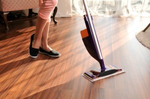 Woman's legs and Swiffer WetJet style electronic mop on wooden floor