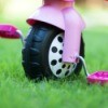 Close up of the front wheel of a pink toddler trike