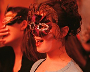 Two young girls in masquerade masks at a party