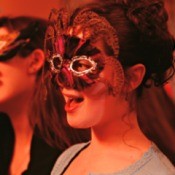 Two young girls in masquerade masks at a party