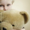 Child sniffing and hugging large stuffed bear