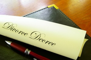 Rolled up divorce decree with pen on legal pad