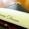Rolled up divorce decree with pen on legal pad