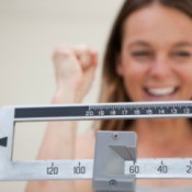 Excited woman weighing herself.