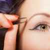 Close up of woman with thin eyebrows plucking them