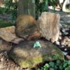 little green frog statue on stone "throne"